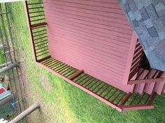 an overhead view of a red house with stairs leading up to the roof and side yard