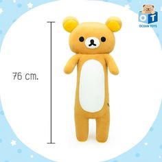 a teddy bear is standing next to a ruler