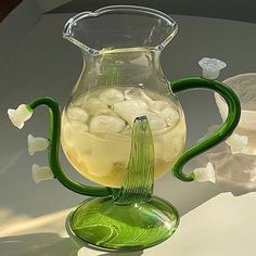 a green glass pitcher filled with ice and water