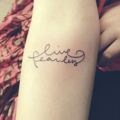 a woman's arm with the word live fearless tattooed on her left side leg