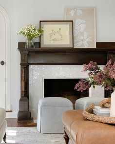 a living room filled with furniture and a fire place in front of a white wall