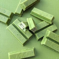 several pieces of green chocolate sitting on top of a table next to eachother