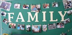 a family photo hanging on a green wall with clothes pins and photos pinned to it