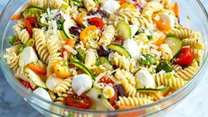 a bowl filled with pasta salad on top of a table