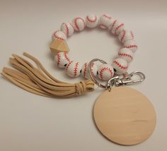 a wooden keychain with a baseball charm attached to it