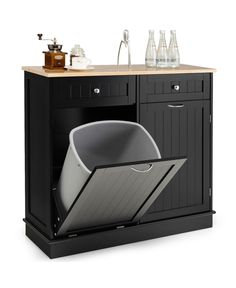 an open dishwasher sitting on top of a wooden counter next to bottles and glasses