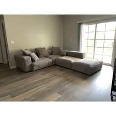 a large sectional couch sitting in the middle of a living room next to a sliding glass door