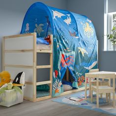 a child's bedroom with a tent bed and toys on the floor in front of it