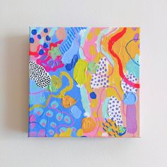 a colorful painting on a white wall with polka dots