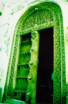 an ornate green door with carvings on it