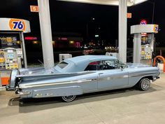 an old car is parked at a gas station