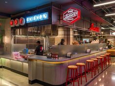 the interior of a fast food restaurant with neon signs on the walls and stools