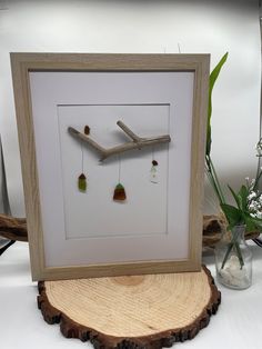 a wooden frame with some small items hanging from it's sides on a table