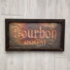 a wooden sign that says bourbon room hanging on a white painted wood paneled wall