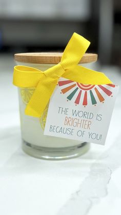 a small jar with a yellow ribbon around it that says the world is brighter because of you