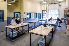 two women sitting at desks working on laptop computers