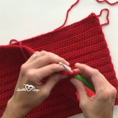 someone is crocheting the side of a red piece of yarn