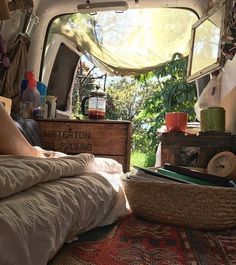 the inside of a camper van with lots of stuff on the floor and bed