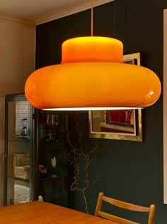 an orange light hanging over a dining room table