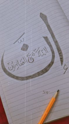 a notebook with arabic writing and a pencil