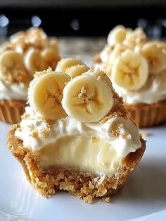 three banana cupcakes are on a white plate