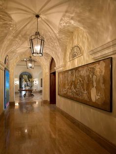 the hallway is lined with paintings and chandeliers, along with an arched ceiling