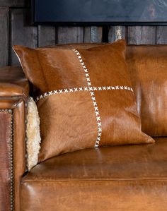 a brown leather couch with two pillows on it