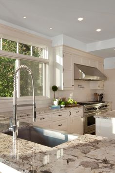 a kitchen with marble counter tops and stainless steel appliances in the middle of the room