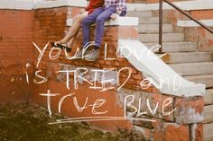 two people sitting on top of a brick wall with the words you're love is tried and true blue