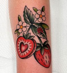 a ladybug and strawberry tattoo on the arm