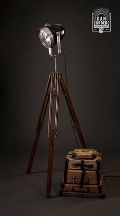 a tripod light sitting on top of two suitcases