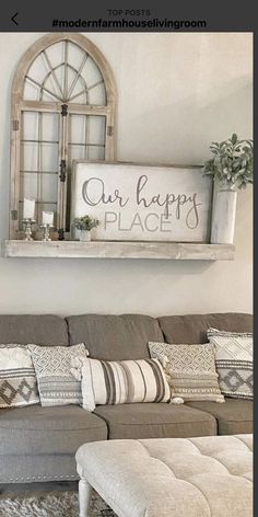 a living room with a couch, ottoman and sign on the wall that says our happy place