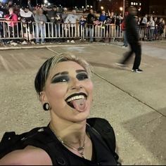 a woman sticking out her tongue in front of a crowd