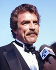 a man in a tuxedo is holding a microphone and talking to the camera