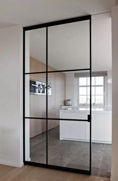 the interior of a modern kitchen with glass doors