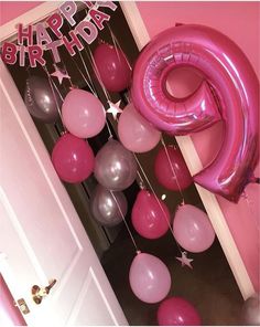 pink and silver balloons are hanging in front of a door with the number six on it