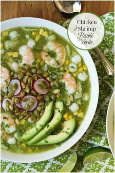 a bowl of soup with shrimp, avocado and red onion on the side