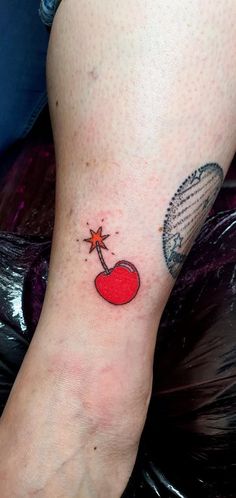 a woman's foot with a small tattoo on her left leg and an apple in the middle