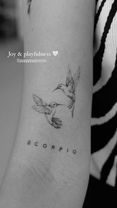 a small tattoo on the arm of a girl with a bird flying above her head