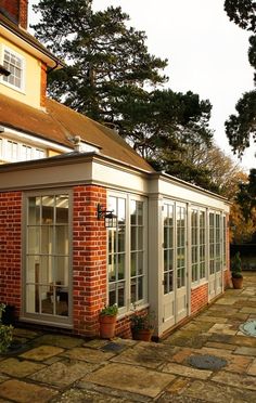 an orange brick building with glass doors and windows on the side of it, next to a pool