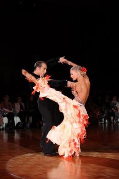 two people dancing on a dance floor in front of an audience