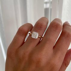 a woman's hand with a ring on it and a diamond in the middle