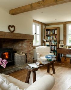 a living room filled with furniture and a fire place in front of a book shelf