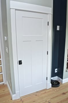 an empty room with a white door and hard wood floor