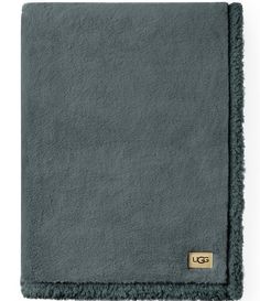 a gray blanket with a gold tag on it