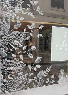 the window is decorated with white leaves and has a sign that says eden on it