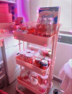 three tiered cart filled with drinks in a kitchen next to a refrigerator and microwave