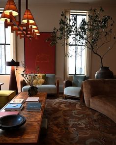 a living room filled with furniture and a tree in the middle of the room on top of a coffee table