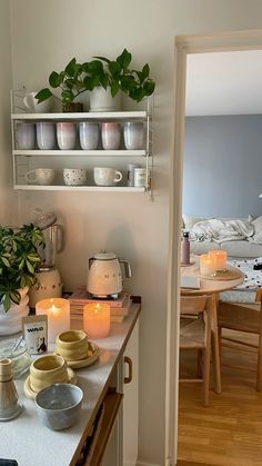 a kitchen counter with plates and cups on it, lit by candles in the middle