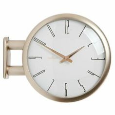 a white clock with gold hands on a wall